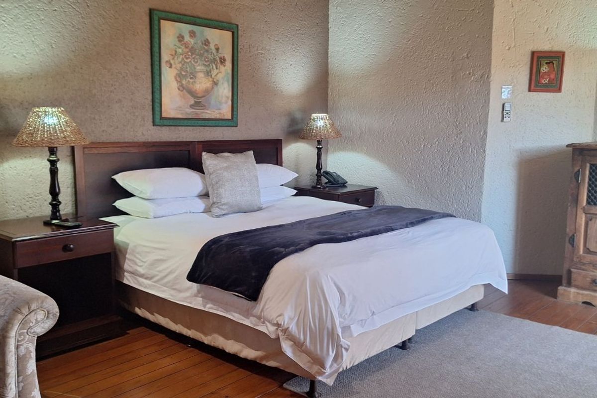 A bedroom featuring textured walls, polished wooden flooring, and integrated wall lighting.