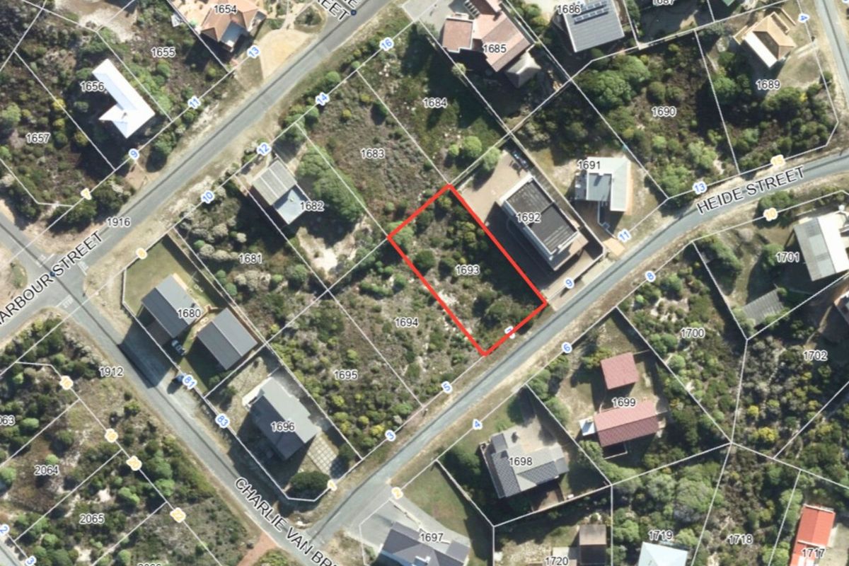Aerial view of a vacant residential plot located in a coastal neighborhood, highlighting the property boundaries and surrounding street layout.