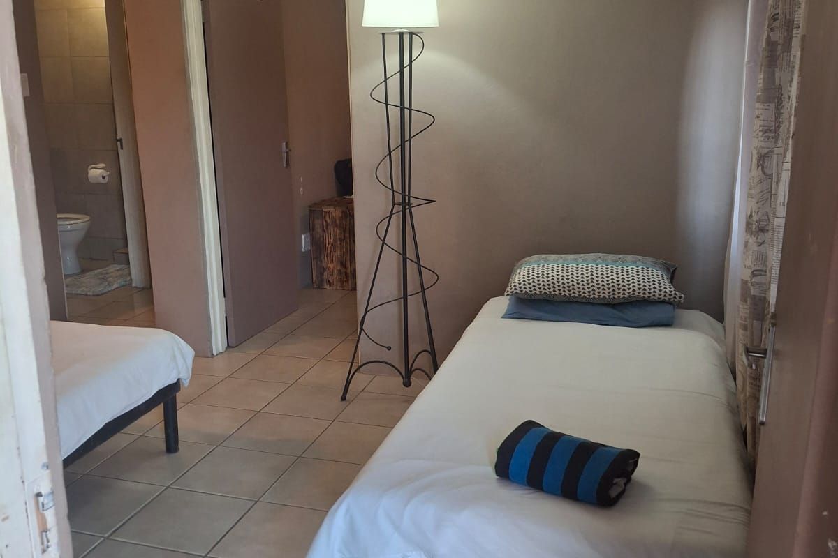 A functional bedroom featuring tiled flooring and an en-suite bathroom, providing a practical and straightforward living space.