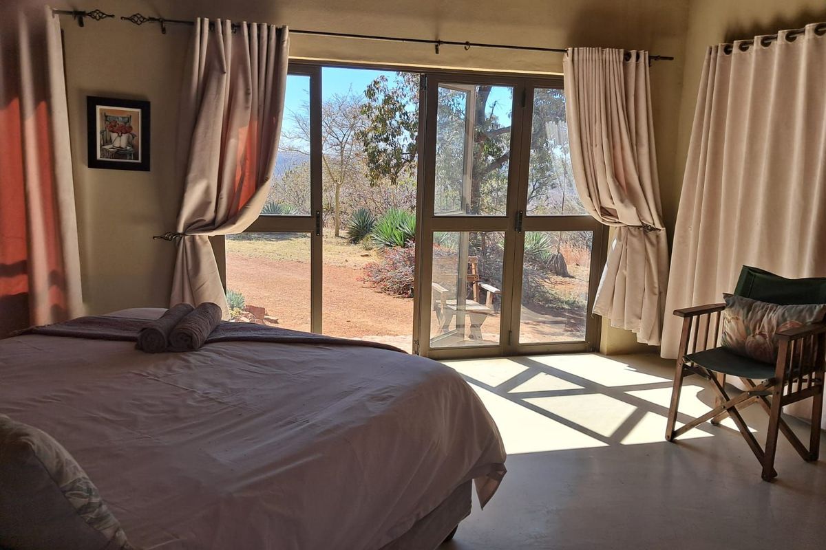 A bedroom featuring large glass sliding doors that provide natural light and direct access to the outdoor garden area.