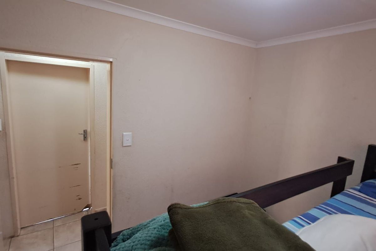 A standard bedroom featuring neutral wall tones, cove cornicing, and an internal door leading to an adjacent space.