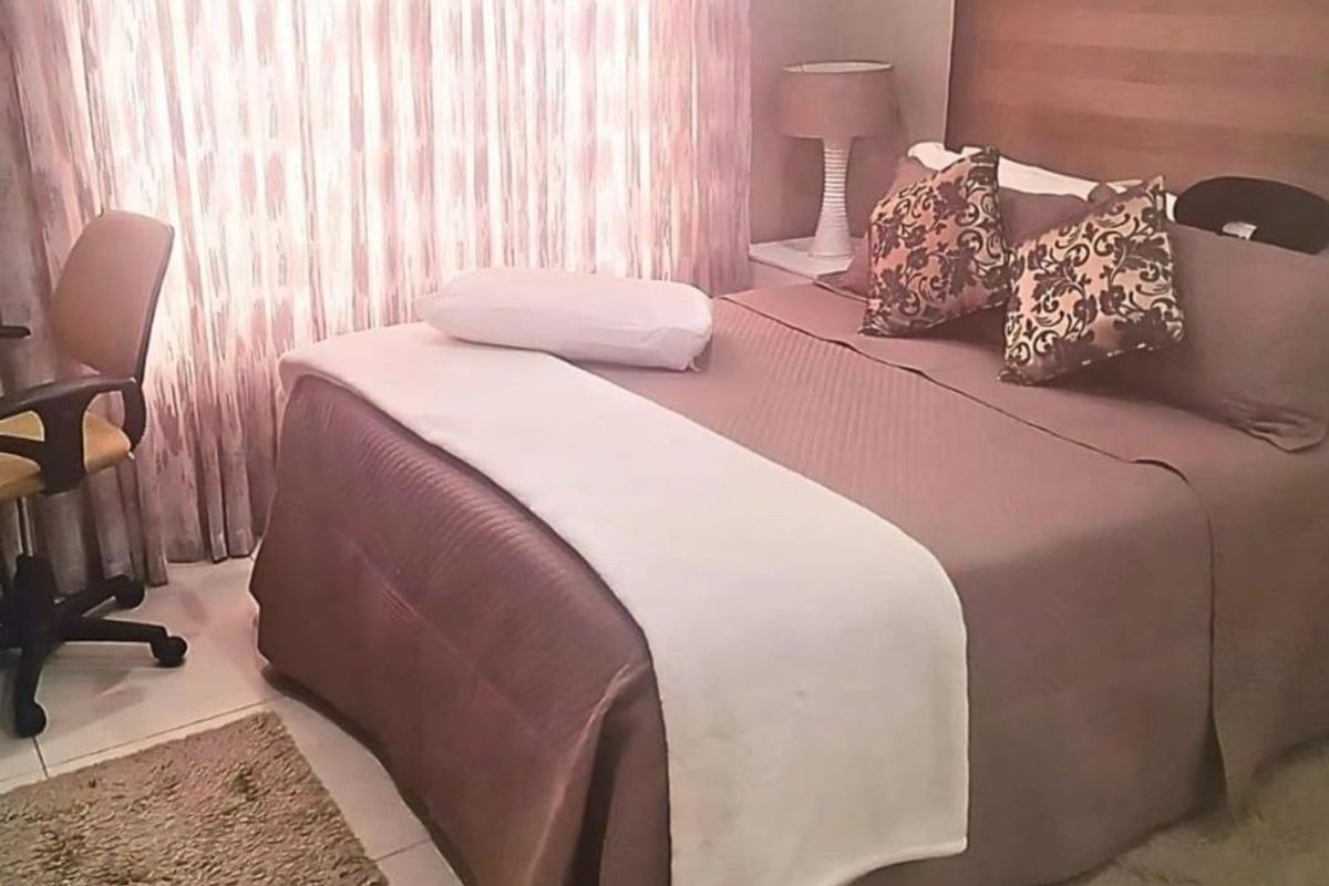 A cozy bedroom featuring neutral tones, tiled flooring, and a built-in headboard, offering a comfortable and functional sleeping space.
