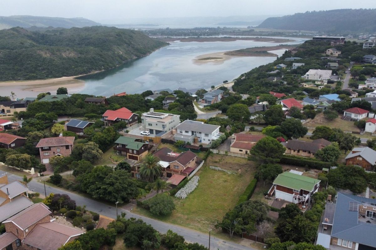 Aerial view of a vacant residential plot situated in a coastal neighborhood, offering proximity to the river and surrounding natural landscape.