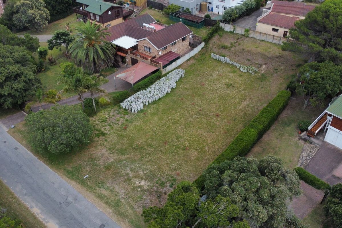 Aerial view of a vacant residential plot featuring established perimeter hedging and a collection of concrete blocks on the site.