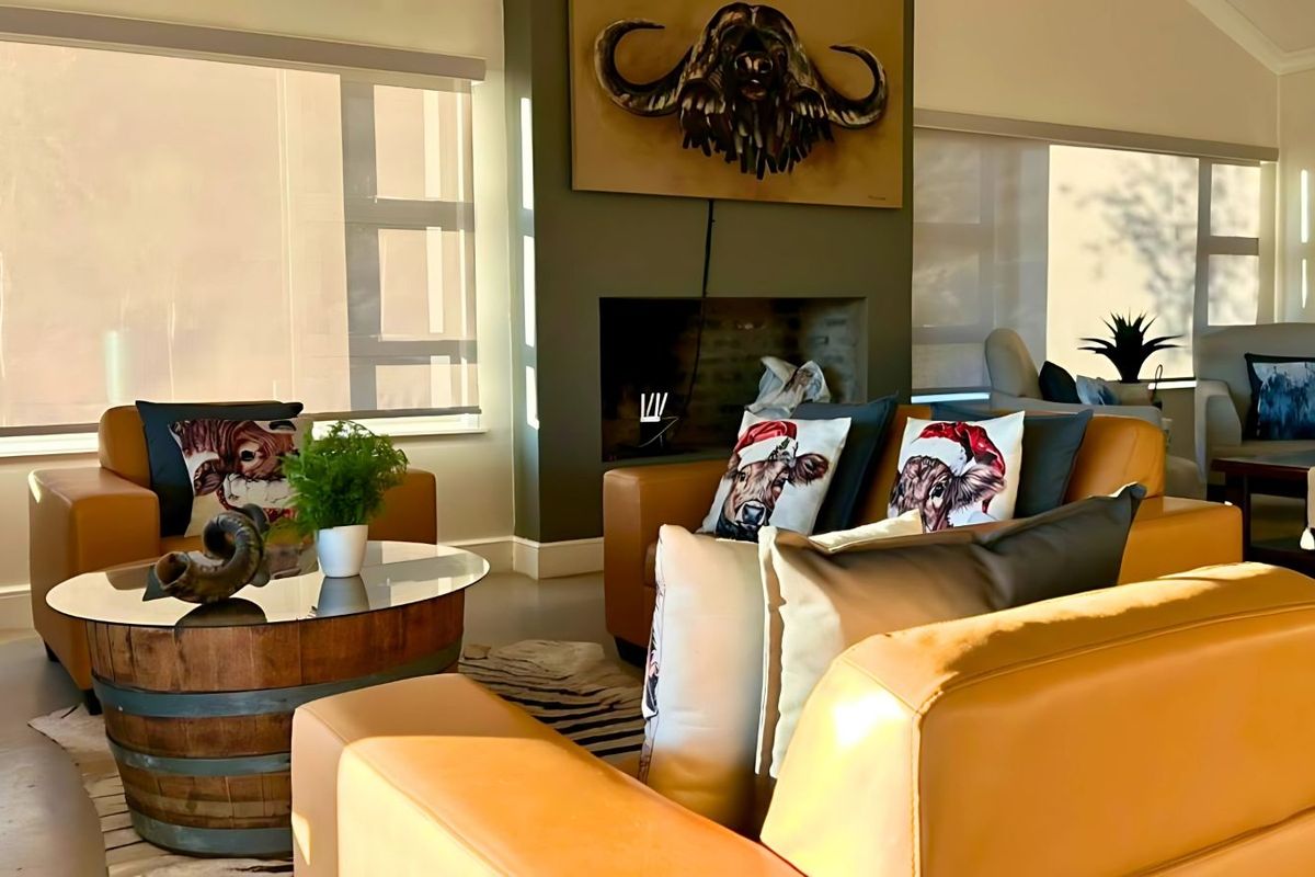 A bright and inviting living room featuring a built-in fireplace, large windows with roller blinds, and polished concrete flooring.