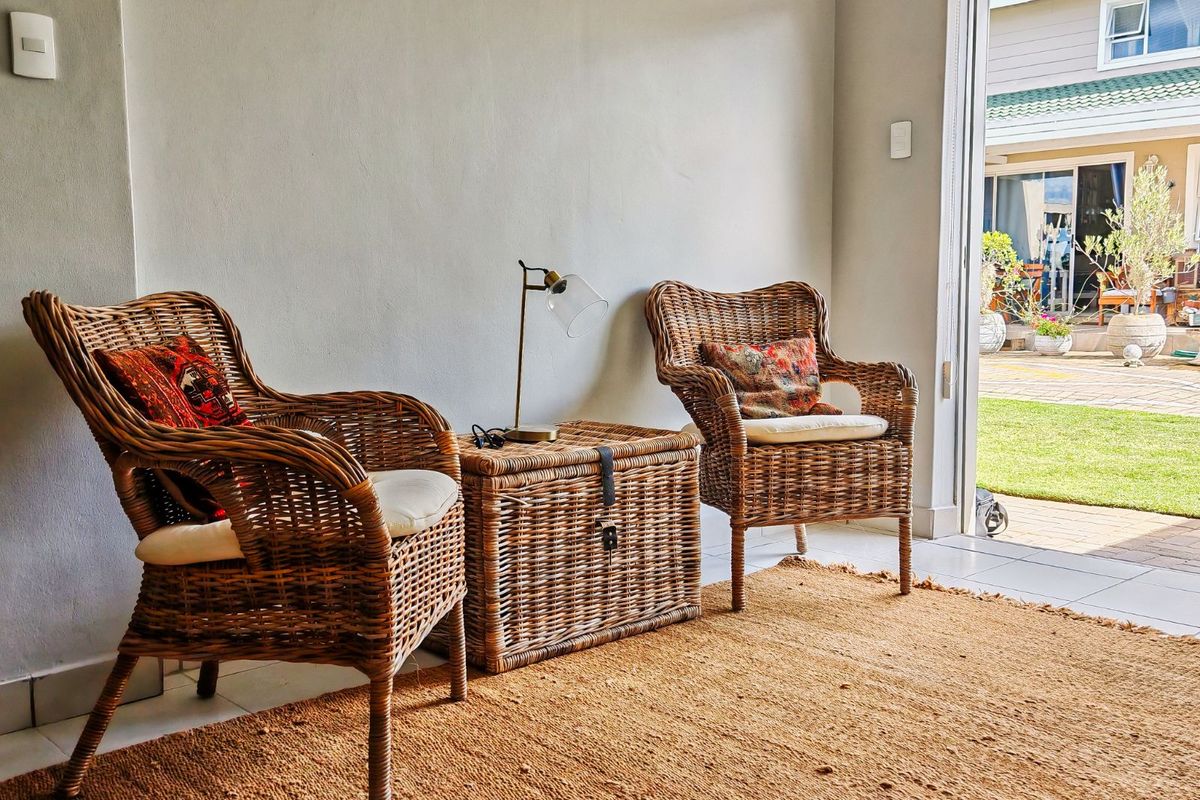 A bright living area featuring tiled flooring and a sliding glass door providing direct access to the rear garden and patio space.