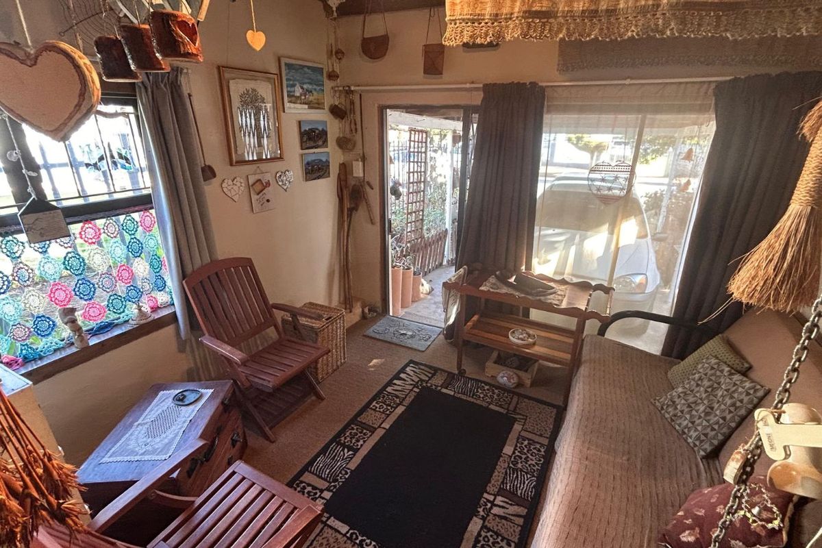 A cozy living room featuring large windows and a sliding glass door providing direct access to the exterior.
