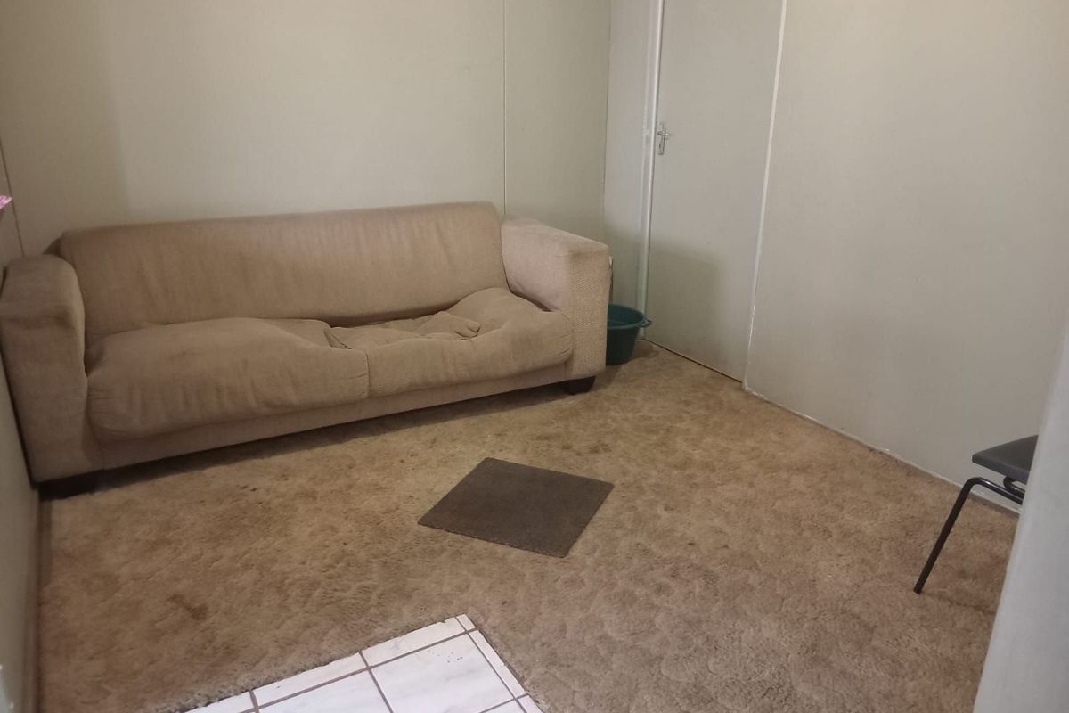 A simple living room area featuring carpeted flooring and a neutral wall finish, providing a basic foundation for potential updates.