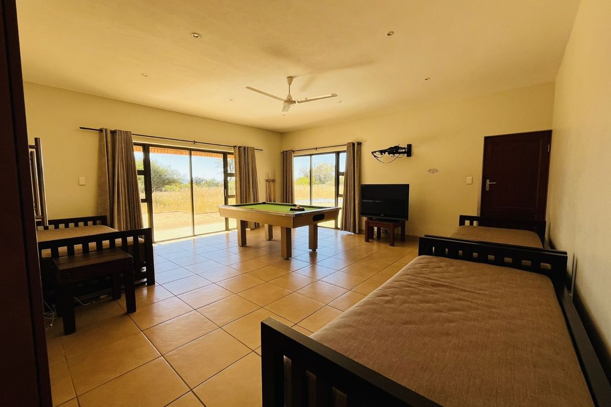 Spacious living area featuring large sliding glass doors, tiled flooring, and a ceiling fan, offering direct access to the outdoor space.