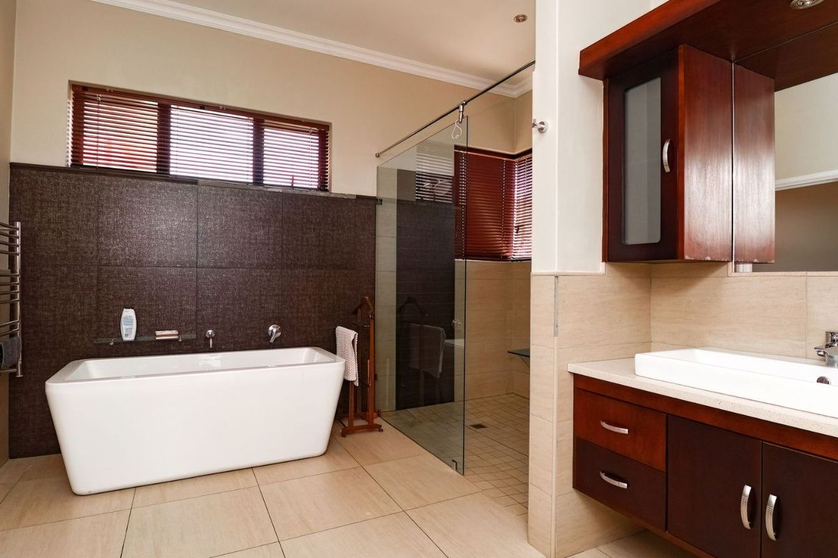 Modern bathroom featuring a freestanding bathtub, a glass-enclosed walk-in shower, and a dark wood vanity with a vessel sink.