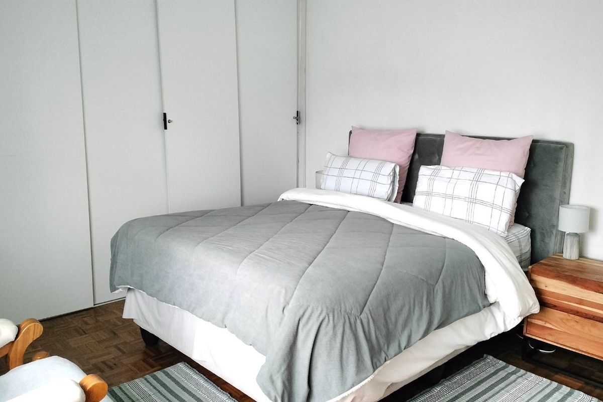 A bedroom featuring parquet flooring and built-in cupboards.