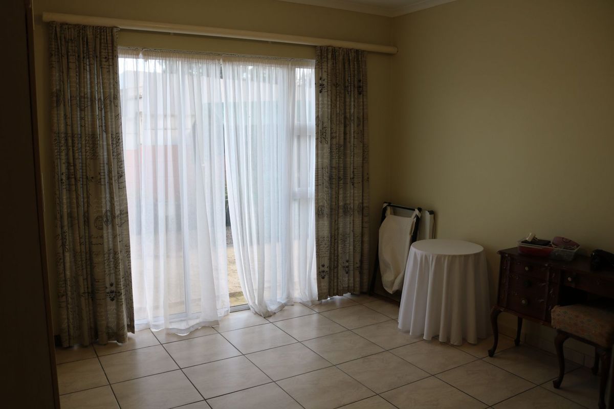 A living area featuring tiled flooring and large sliding glass doors that provide access to the exterior.
