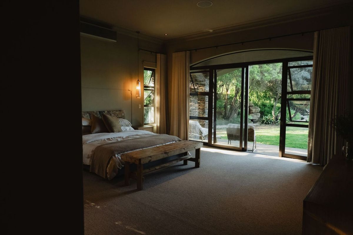 Spacious bedroom featuring large sliding glass doors that open onto a private garden, providing ample natural light and seamless indoor-outdoor flow.