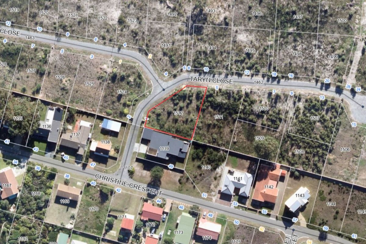 Aerial view of a vacant residential plot highlighted in red, situated within a developed suburban street layout.