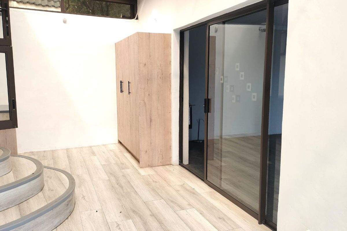 Interior space featuring light wood-look flooring, built-in cabinetry, and large sliding glass doors leading to an adjacent room.