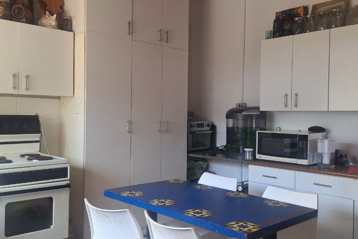 A functional kitchen featuring white cabinetry, built-in stove, and ample storage space, offering a practical layout for daily meal preparation.