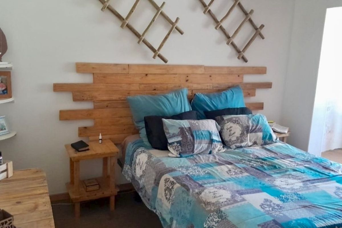 A bedroom featuring a custom wooden pallet headboard and wall-mounted decorative wooden lattice elements.