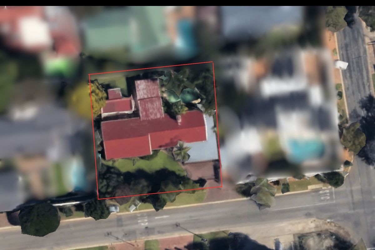 An aerial view of the property showing the house footprint, roof structure, and surrounding garden area within the highlighted boundary.