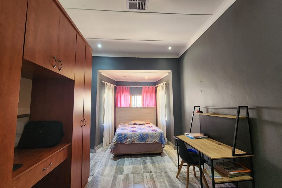 A bedroom featuring built-in wooden cabinetry, recessed ceiling lighting, and a dedicated alcove area for the bed.