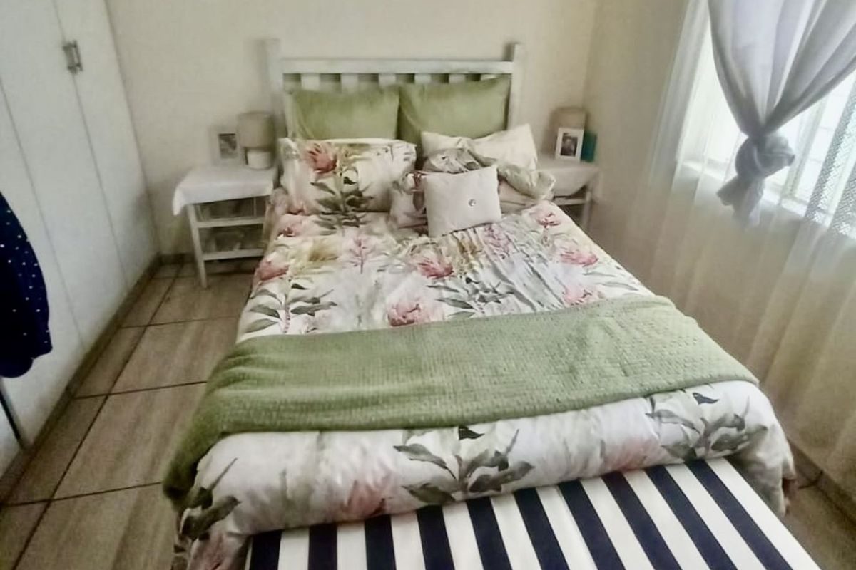 A cozy bedroom featuring built-in wardrobes and tiled flooring, offering a functional and comfortable living space.