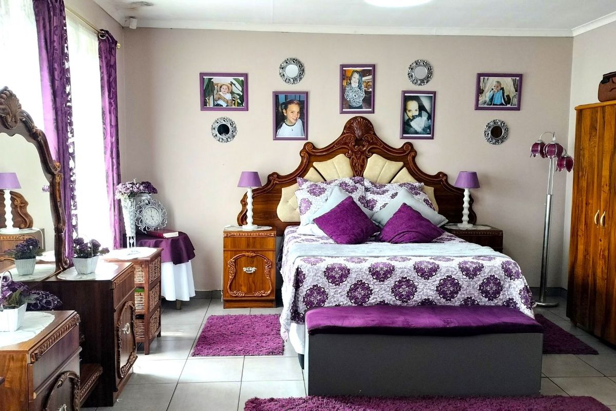 A spacious bedroom featuring tiled flooring and a neutral wall finish, providing a comfortable and functional sleeping area.