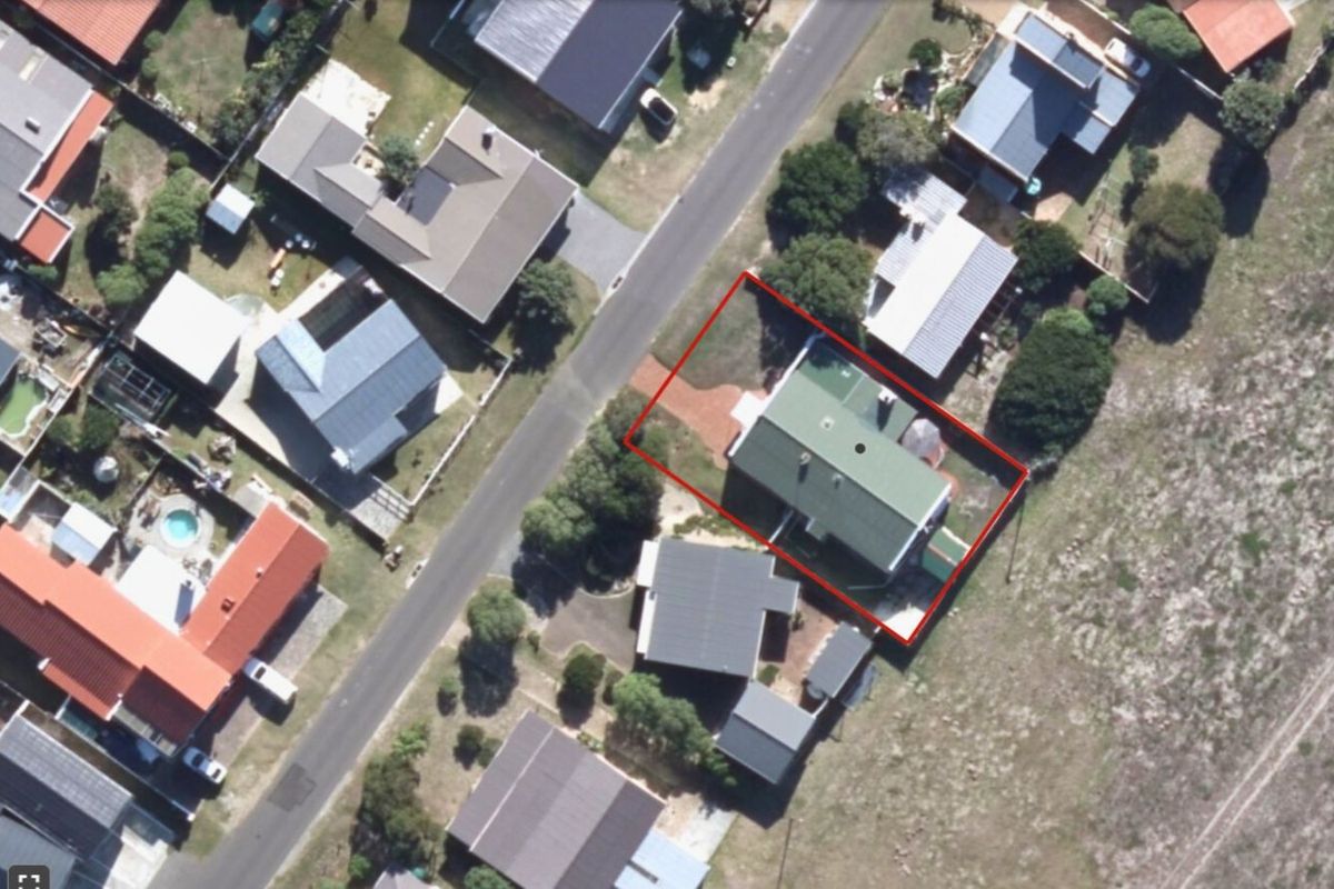 Aerial view of the property highlighting the house footprint, roof structure, and surrounding garden area within the residential neighborhood.