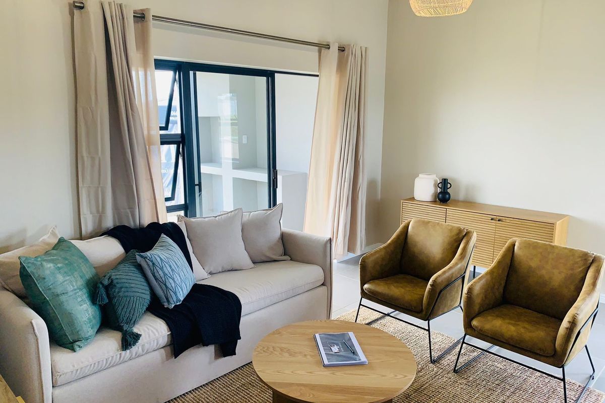 A bright and inviting living room featuring large sliding glass doors that provide natural light and access to an outdoor patio area.