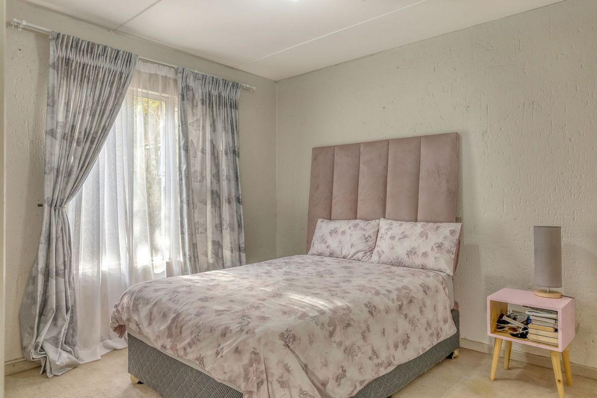A bedroom featuring a window with curtain tracks and carpeted flooring.
