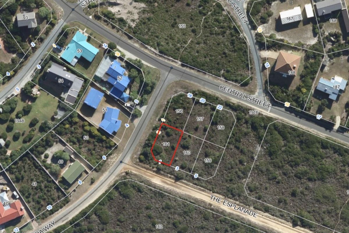 Aerial view of a vacant residential plot in a coastal neighborhood, highlighting the property boundaries and surrounding street layout.