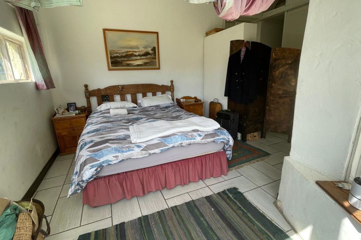 A simple bedroom featuring tiled flooring and basic wall finishes, offering a functional space with potential for cosmetic updates.