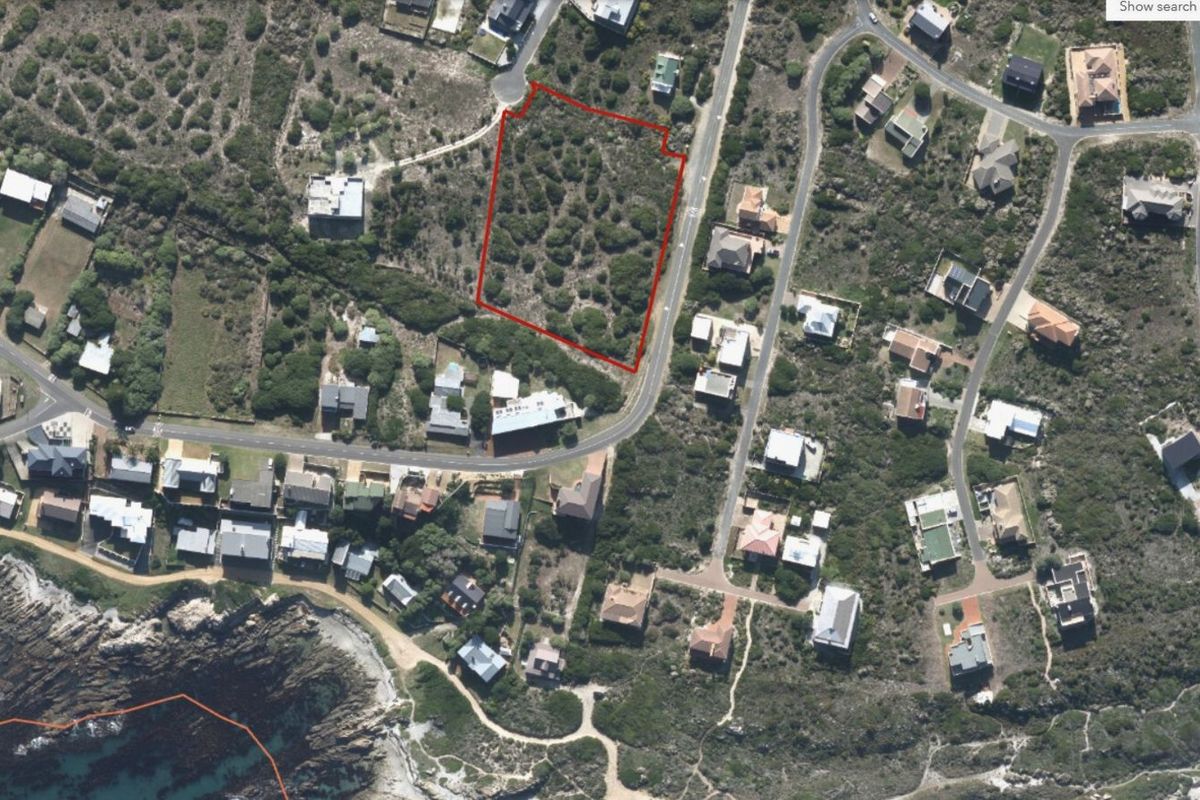 Aerial view of a vacant residential plot in a coastal estate, highlighting the property boundaries and surrounding neighborhood context.