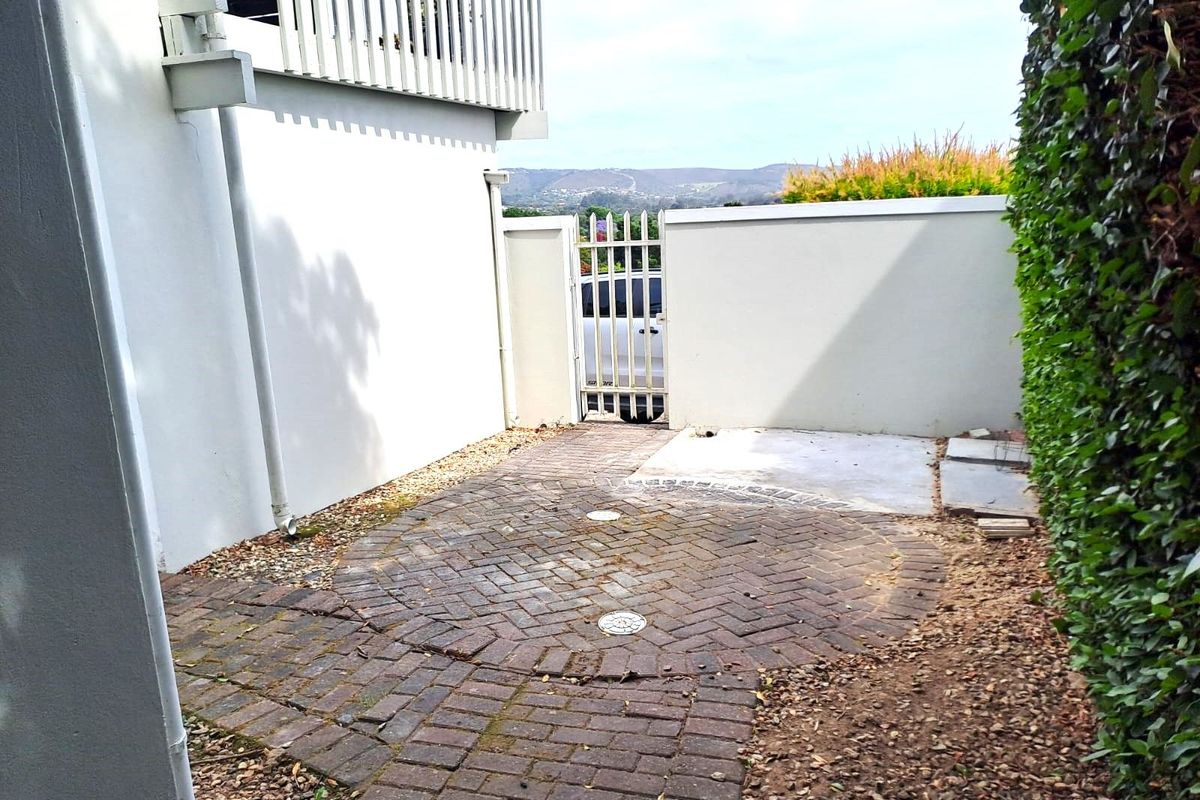 A private outdoor courtyard area featuring brick paving, a secure metal gate, and perimeter walling, offering a functional space for outdoor use.