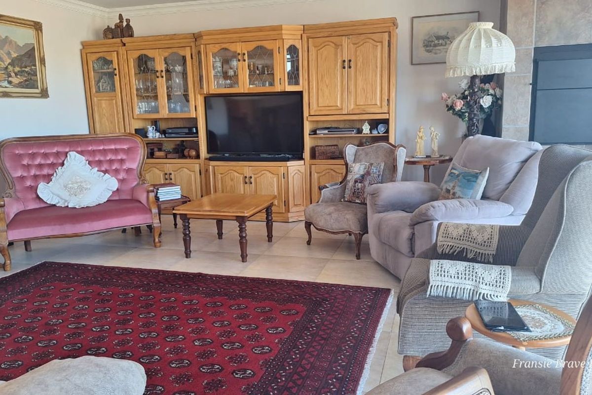 A traditional living room featuring a built-in wooden wall unit and a tiled fireplace surround.