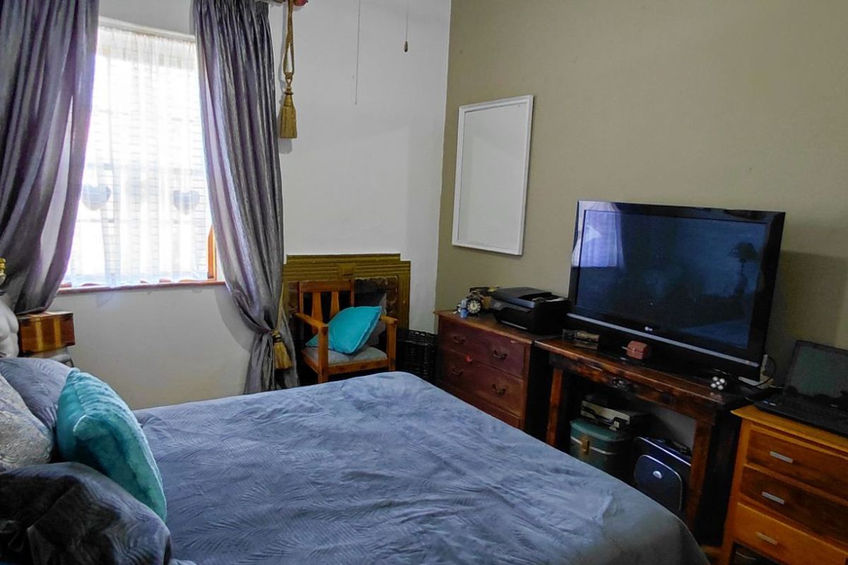 A bedroom featuring a window with curtains and neutral wall finishes.