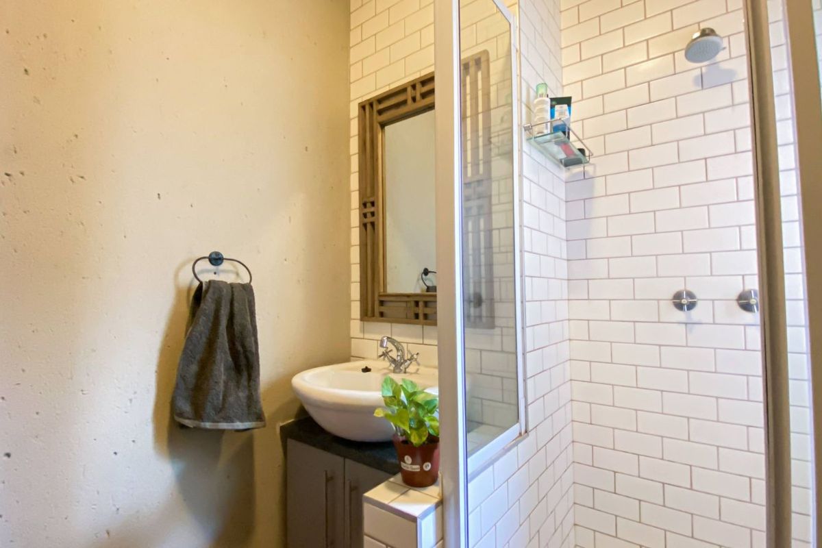 A modern bathroom featuring a white subway-tiled shower enclosure, a vessel sink vanity, and a framed wall mirror.