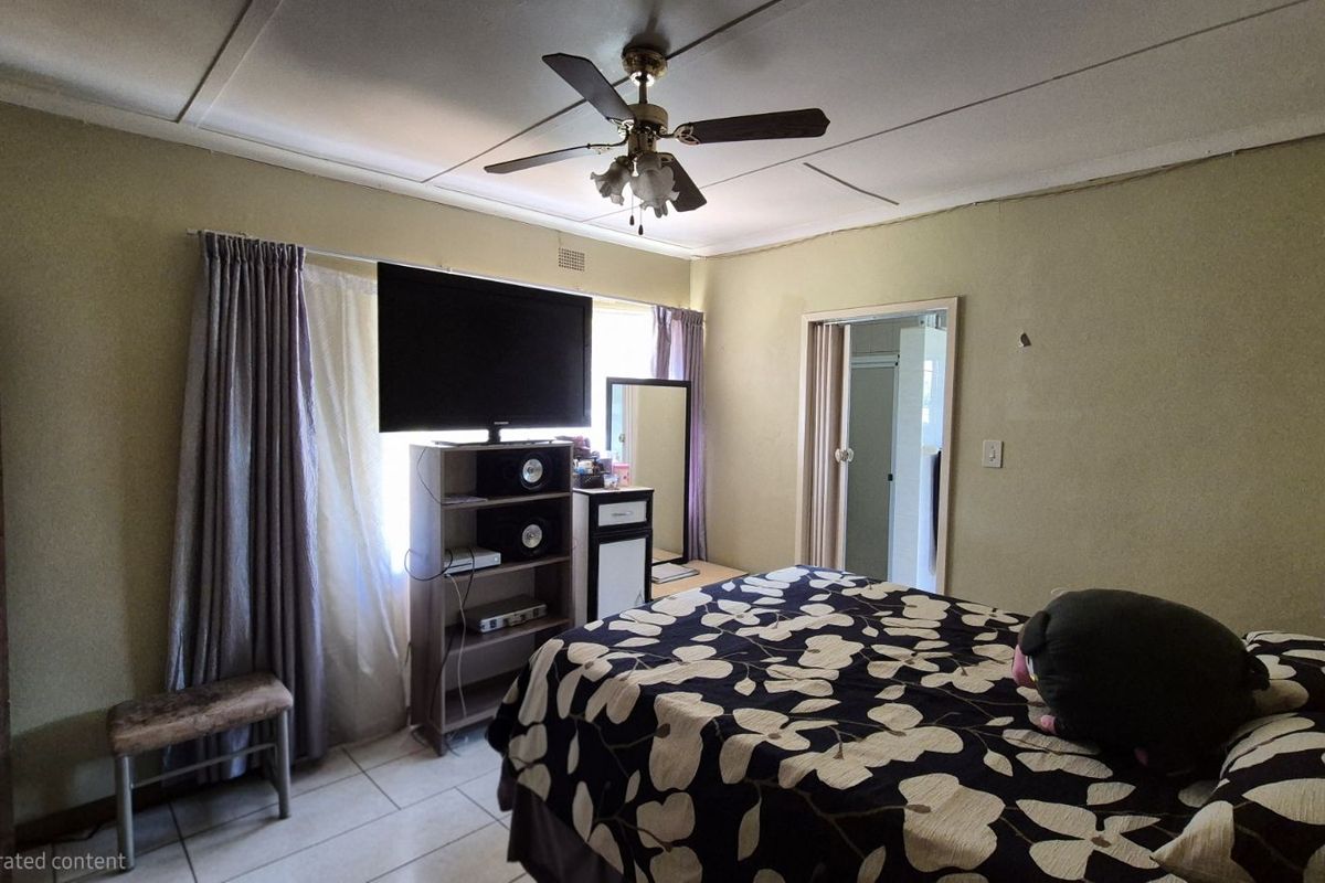 A bedroom featuring tiled flooring, a ceiling fan, and direct access to an adjoining room.