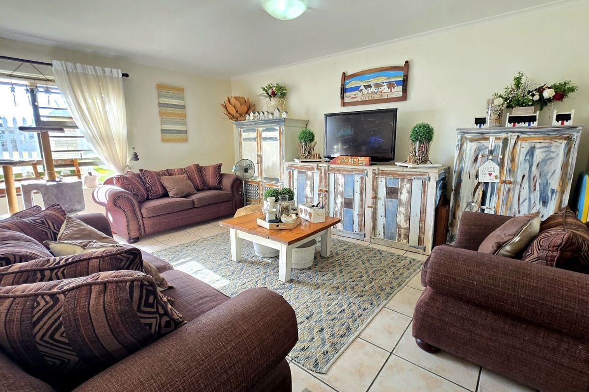 A comfortable living room featuring tiled flooring and large windows that provide natural light, creating a welcoming and functional space.