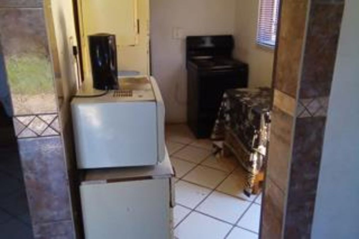 A compact kitchen area featuring tiled flooring and basic built-in appliance space, requiring modernization to improve functionality and aesthetic appeal.