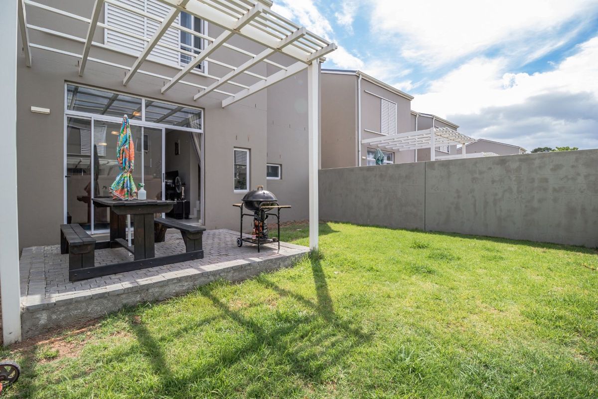 A private rear garden featuring a paved patio area with a pergola, providing an ideal space for outdoor relaxation and entertaining.