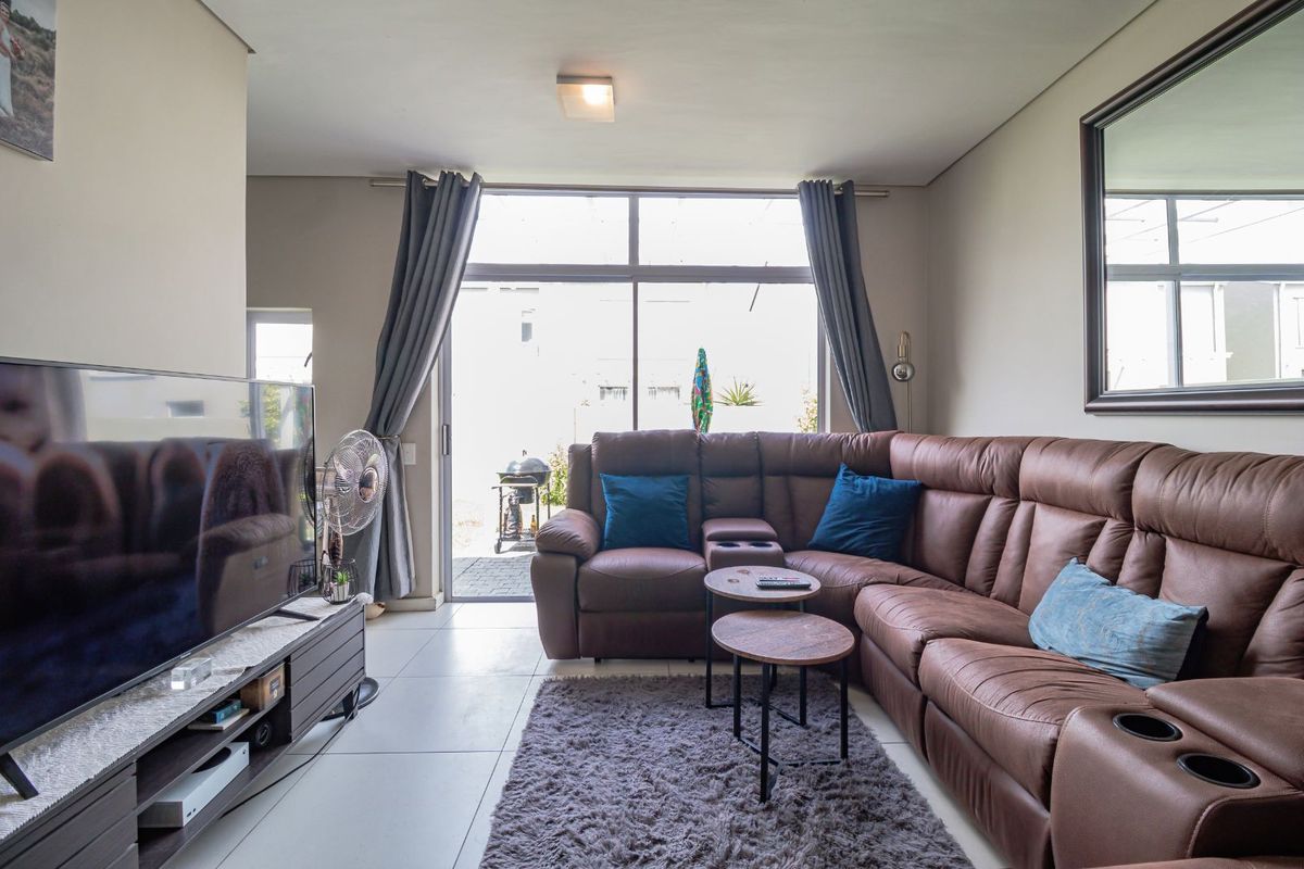 A comfortable living room featuring large sliding glass doors that provide natural light and direct access to the outdoor patio area.