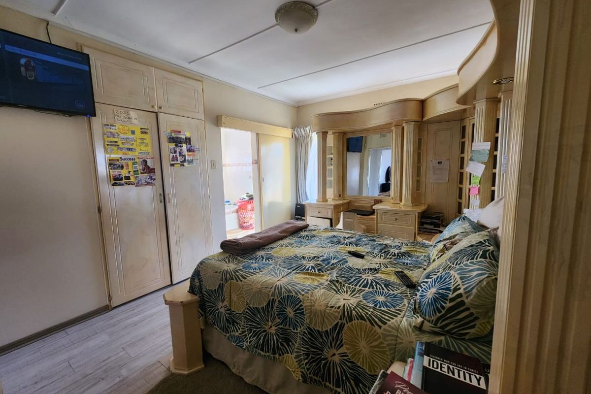 A bedroom featuring extensive built-in cabinetry, a vanity unit, and direct access to an en-suite bathroom.