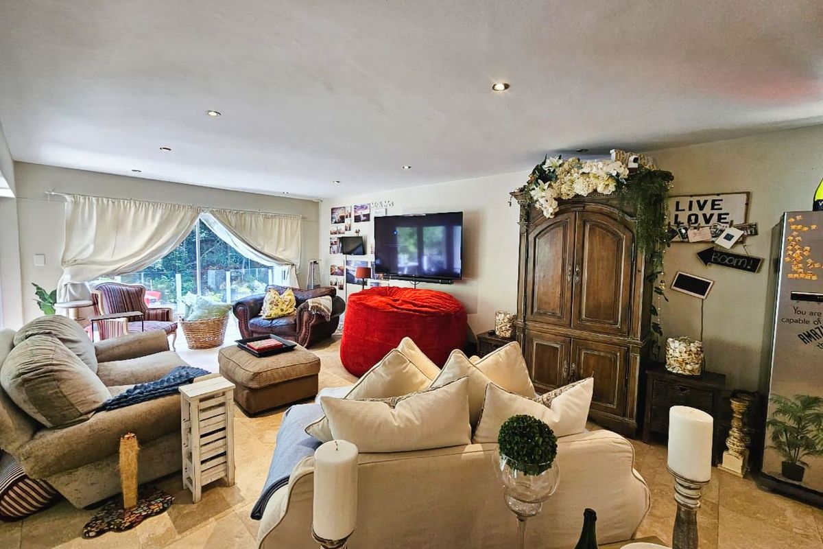 Spacious living room featuring tiled flooring, recessed ceiling lighting, and large sliding glass doors providing access to the outdoor area.