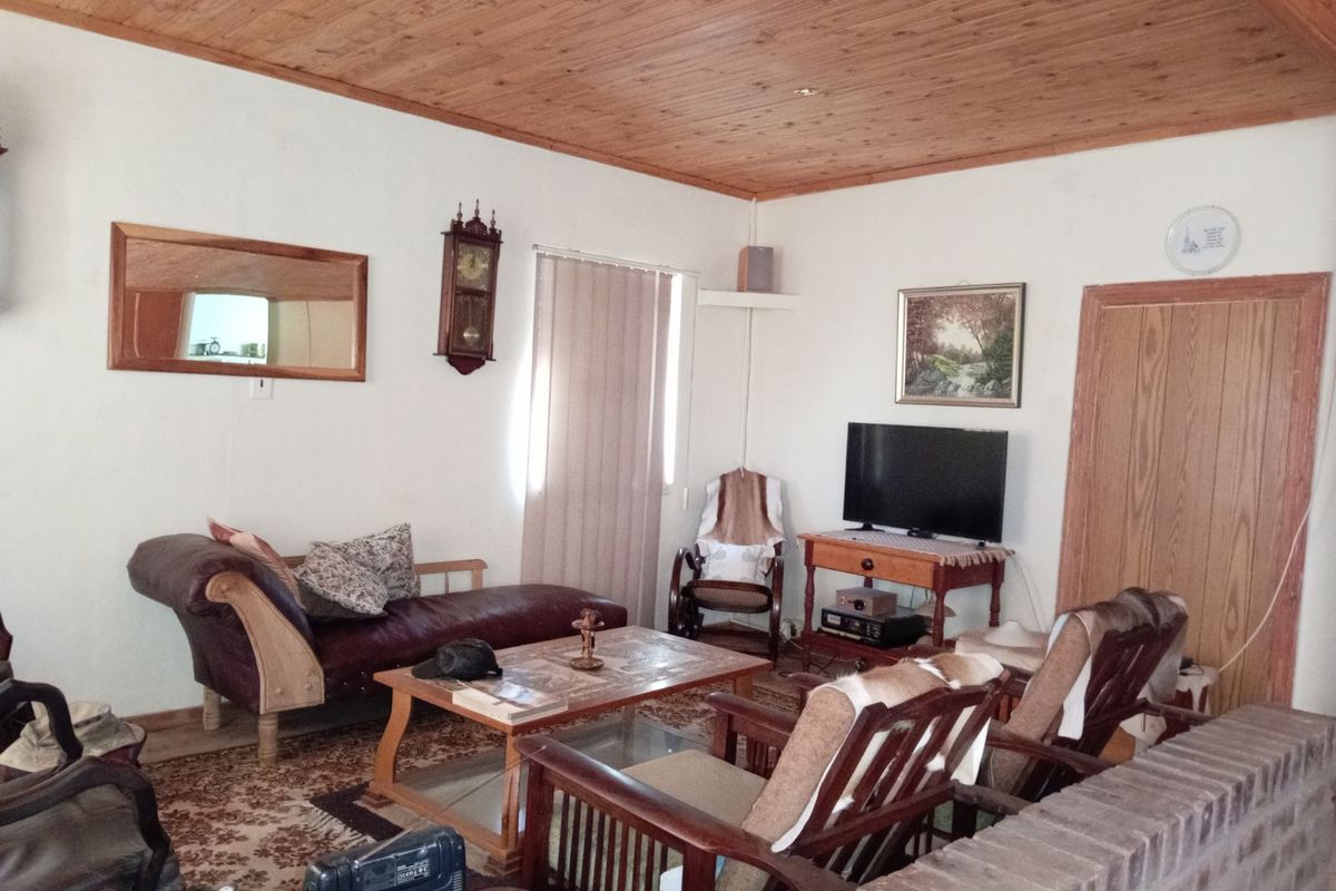 A cozy living room featuring a warm timber-paneled ceiling and a brick partition wall, creating a traditional and inviting atmosphere.