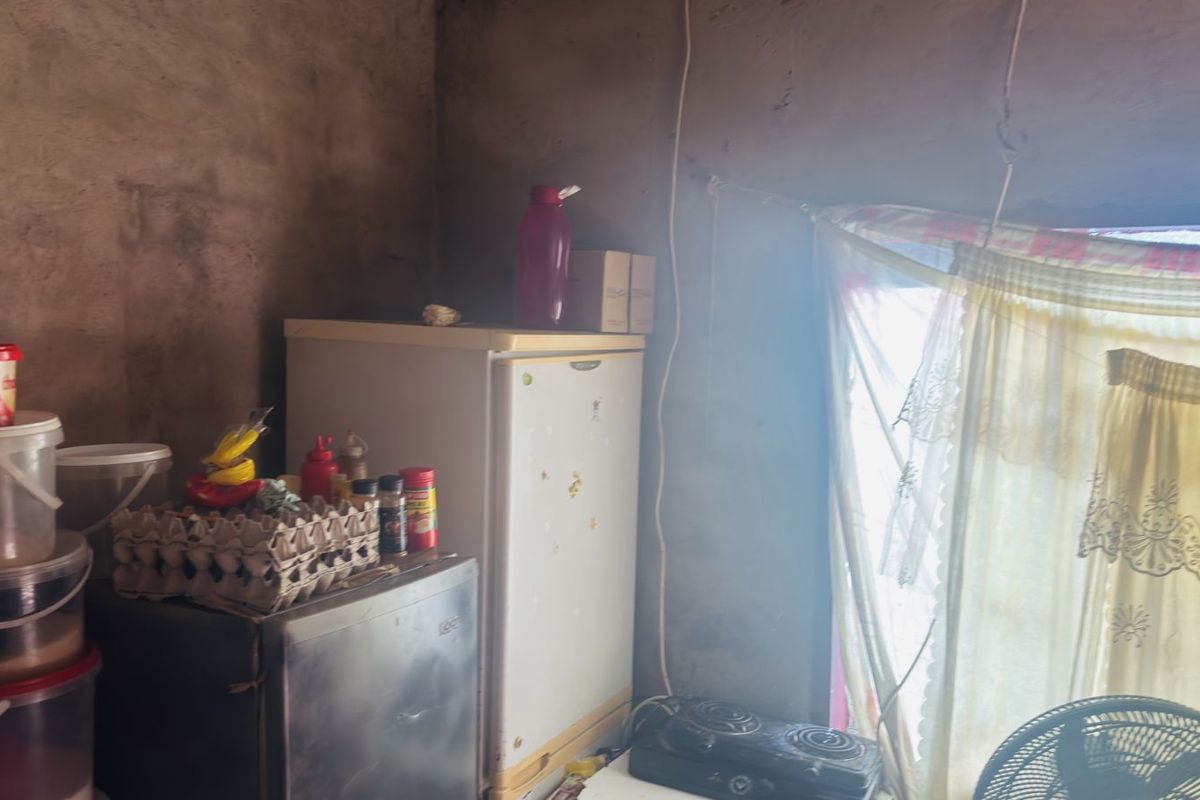A basic kitchen area featuring unfinished walls and exposed wiring, providing a functional but dated space for food preparation.