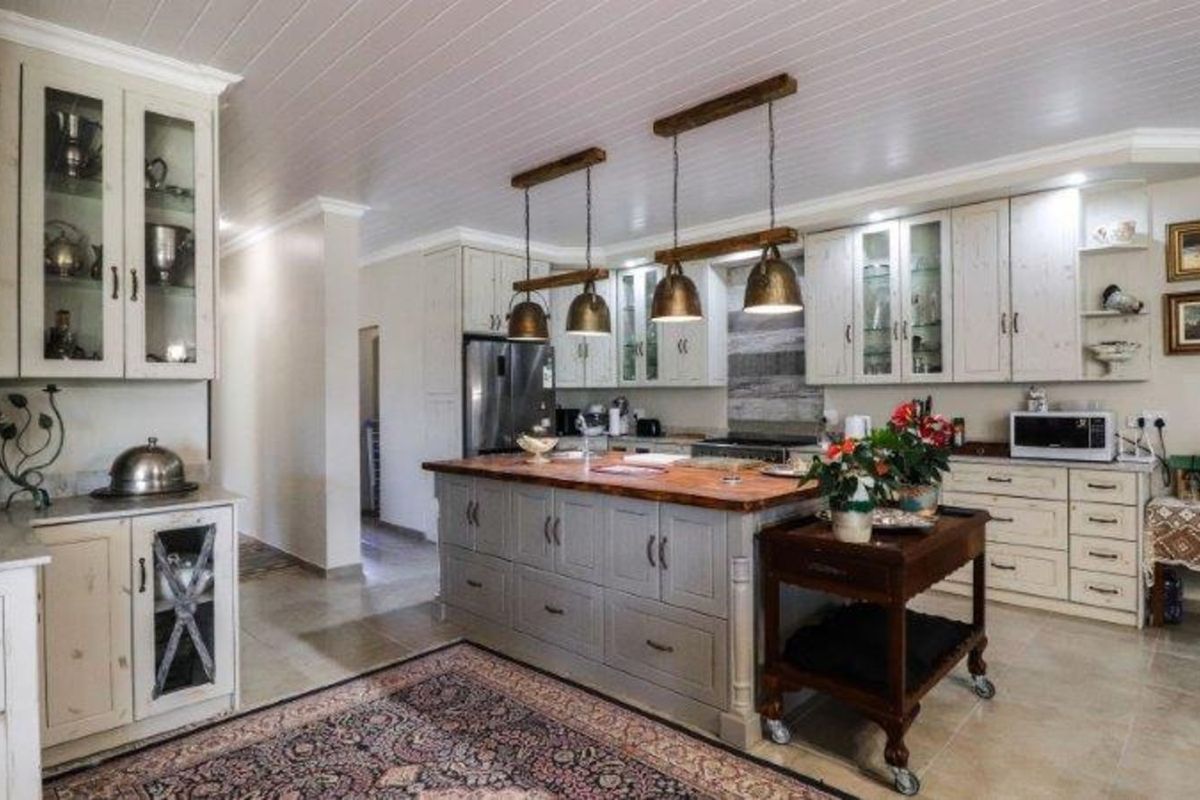 Spacious kitchen featuring a large central island with a wooden countertop, custom cabinetry, and integrated lighting fixtures.