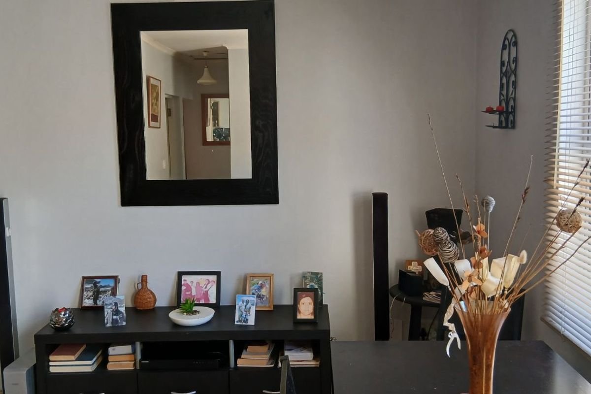 A view of a living area featuring a window with horizontal blinds and a neutral wall finish.