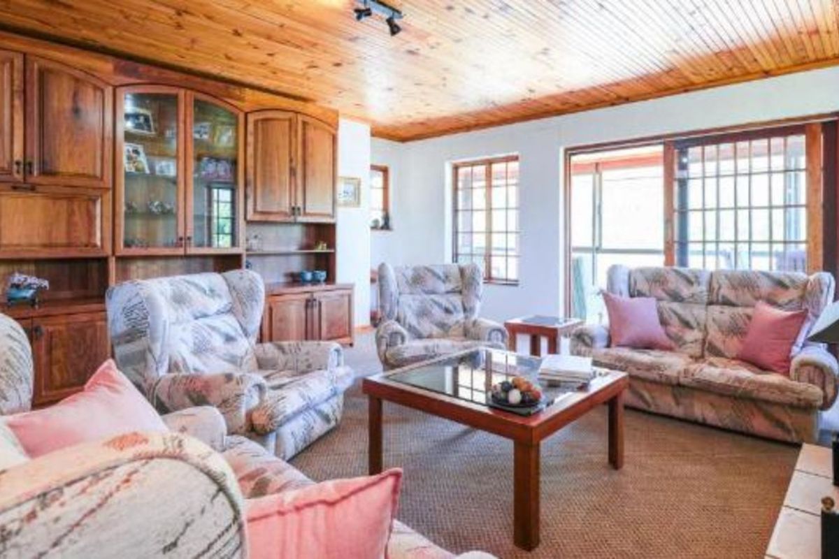 A living room featuring a wood-paneled ceiling, built-in wooden cabinetry, and sliding glass doors leading to an outdoor area.