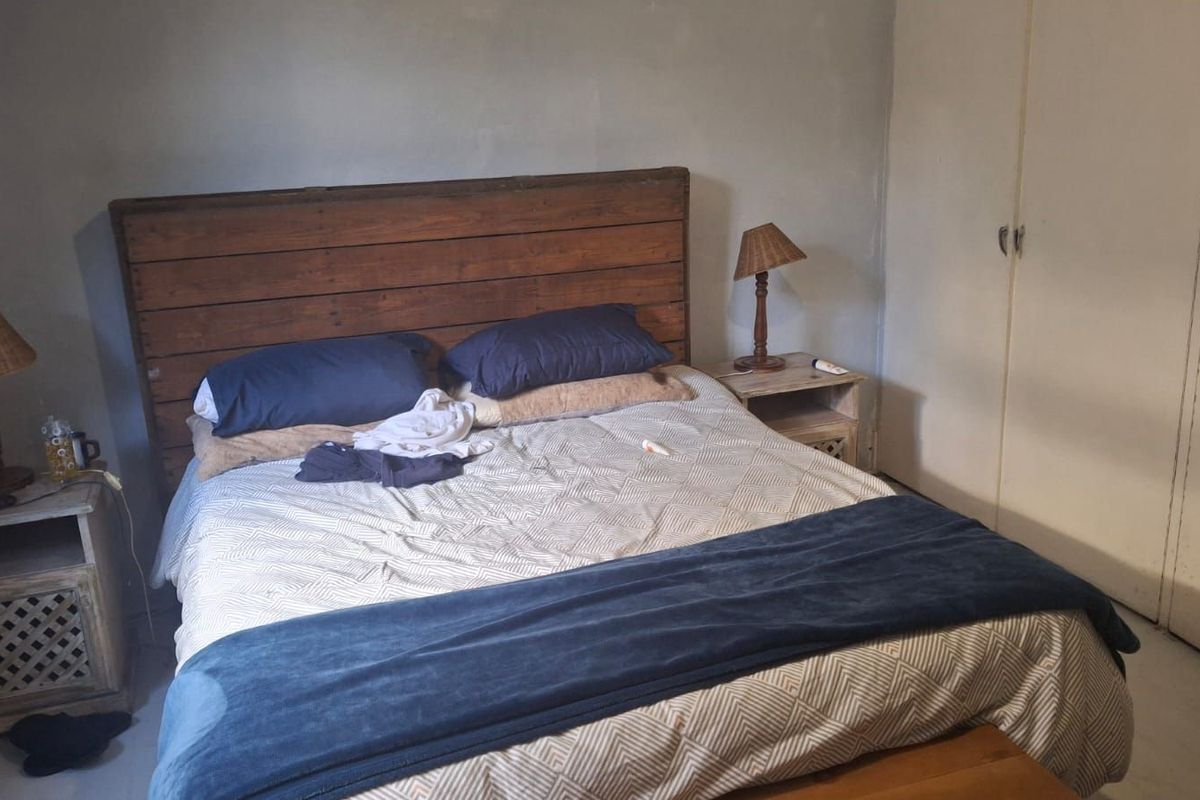 A bedroom featuring built-in cupboards and neutral wall finishes, providing a functional space for rest.