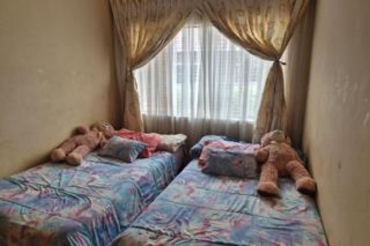 A compact bedroom featuring two single bed spaces positioned side-by-side with a large window providing natural light.