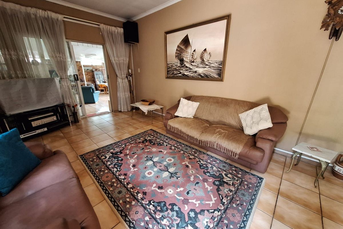 A comfortable living room featuring tiled flooring and sliding glass doors that provide access to an adjoining patio area.